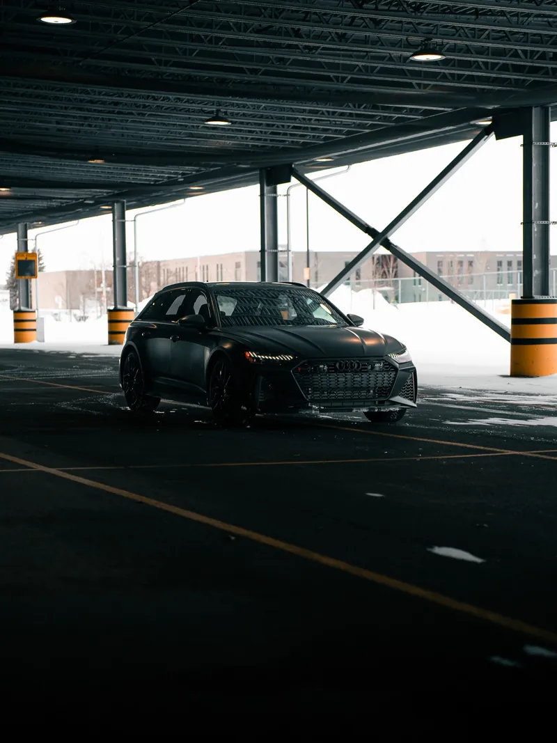 Audi RS6 grise mate sous une structure de béton