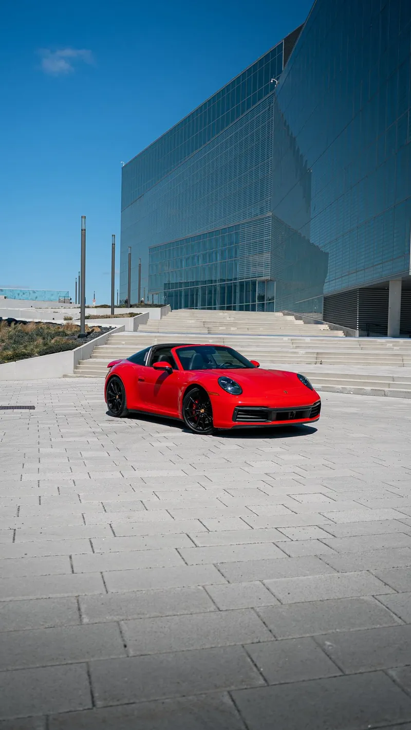 Porsche 911 Targa rouge devant un immeuble vitré